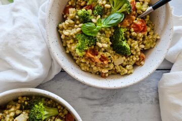 photo culinaire de sarrasin crémeux aux brocolis, tomates séchées et mozzarella avec des pignons de pin et du basilic