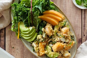 photo culinaire d'une salade de quinoa aux crevettes et melon avec de l'avocat, des amandes effilées, des jeunes pousses et une sauce sucrée-salée