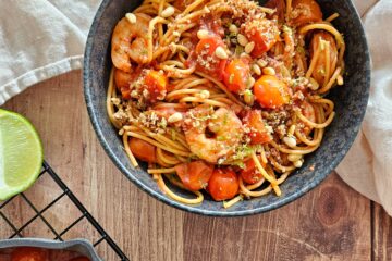 photo culinaire de pâtes aux crevettes à l'ail, tomate, citron et crumble de pignons de pin avec des zestes de citron vert et du sumac