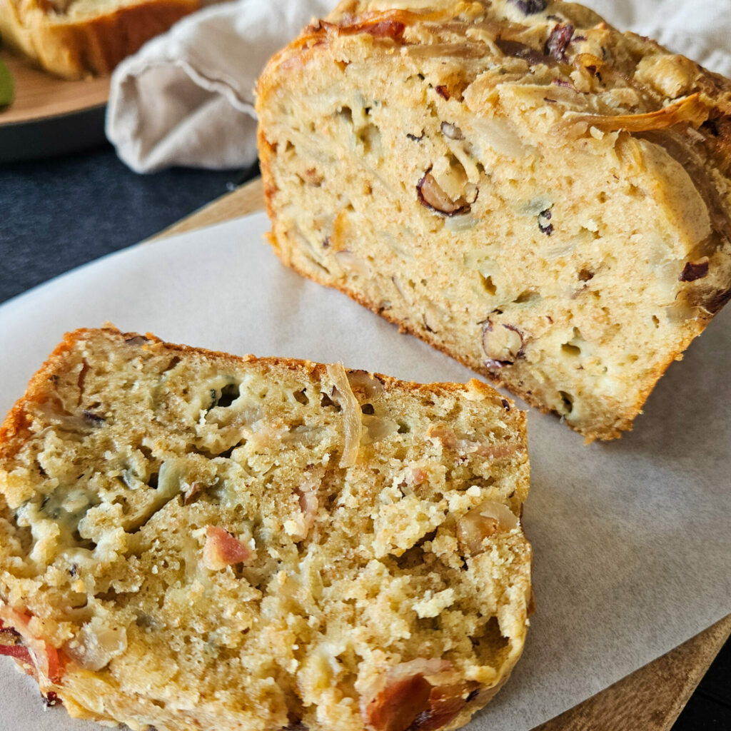 photo culinaire de près d'un cake aux oignons caramélisés, bleu, lard et noisettes