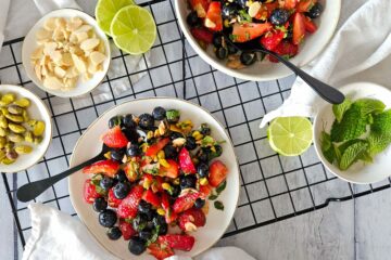 photo culinaire d'une salade de fruits rouges à la menthe avec des pistaches, des amandes, du citron vert et du miel