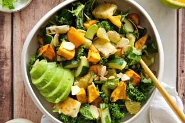 photo culinaire d'une salade de chou kale et patate douce avec une sauce miso orange, de l'avocat et du halloumi