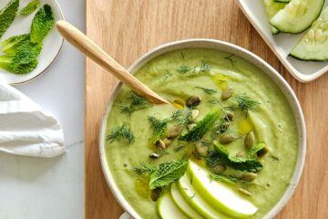 photo culinaire d'une soupe froide concombre et pomme avec de l'avocat, du citron vert, de la menthe, de l'aneth et des graines de courge