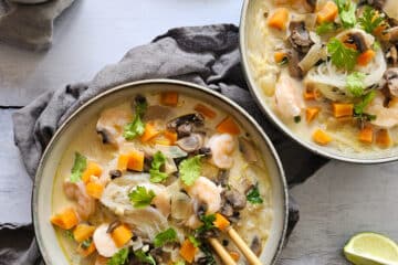 photo culinaire d'une soupe au lait de coco et crevettes avec des vermicelles de soja, des carottes et des champignons