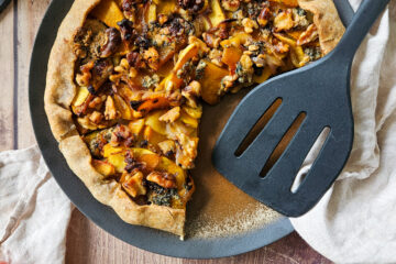 photo culinaire d'une tarte à la courge, pomme, bleu et noix avec du miel
