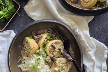 photo culinaire de calamars farcis à la viande et champignons avec du riz basmati, du persil et des pignons de pin