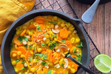 photo culinaire d'un curry crémeux de pois chiches et carottes aux noix de cajou avec du persil et des noix de cajou