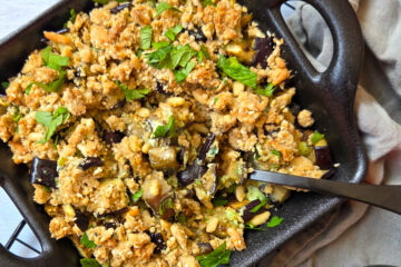 photo culinaire d'un crumble d'aubergines au sésame et pignons de pin avec une crème de feta au persil