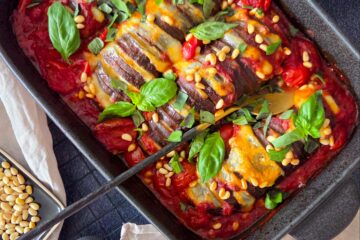 photo culinaire d'aubergines hassalback à la mozzarella avec une sauce aux tomates cerises et graines de fenouil