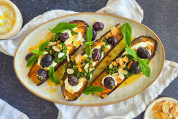 photo culinaire d'aubergines rôties au yaourt citronné et chermoula avec des olives et des amandes effilées