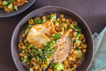 photo culinaire d'une salade de petit épeautre, pois chiches et tahini avec du halloumi