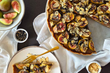photo culinaire d'une tarte aux figues et crème d'amandes au sésame avec des amandes effilées et des graines de sésame